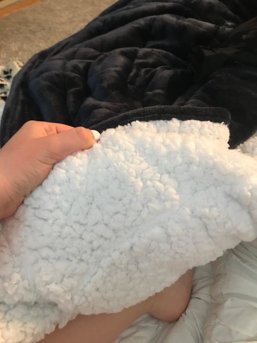 A reviewer showcasing the underside of the blanket