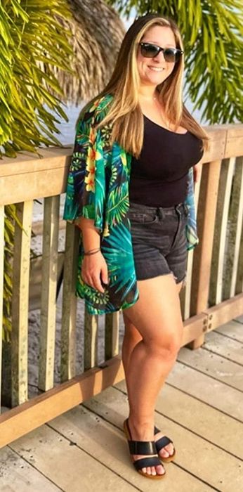 Reviewer rocking the black and green tropical cardigan.