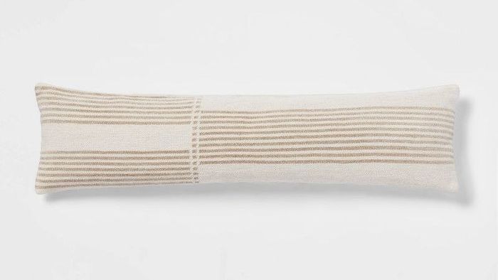 a long, stylish pillow featuring cream and white stripes