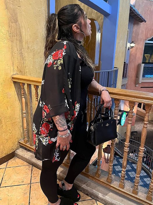 Reviewer sporting a chic black floral cardigan.