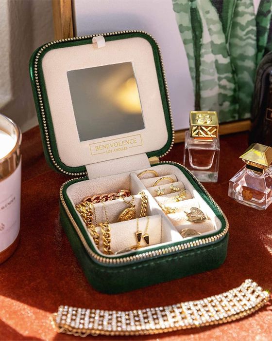 A green velvet square zipper case featuring ring holders and compartments for necklaces and earrings, designed for organized packing of your precious pieces.