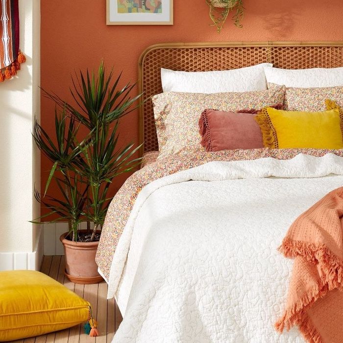 a bed beautifully dressed with multicolored floral-patterned sheets