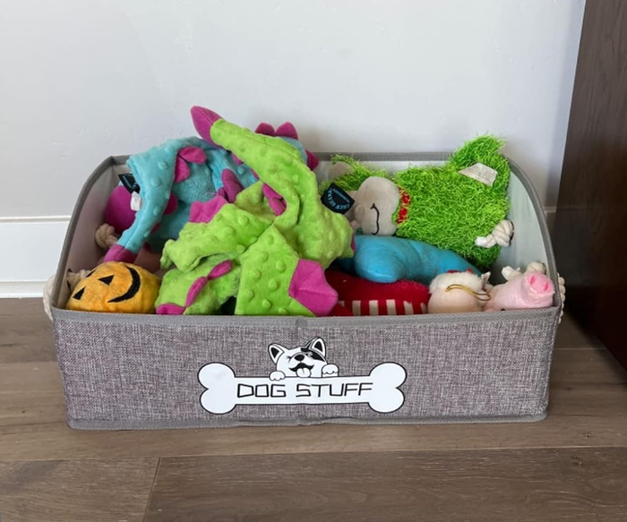 A grey bin belonging to a reviewer, filled to the brim with dog toys.