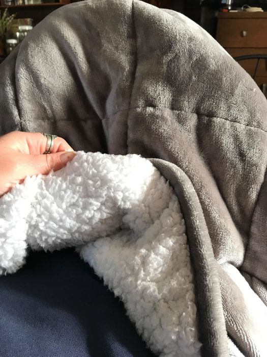 A reviewer displaying the underside of the blanket