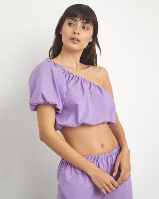 Model wearing a one-shoulder crop top.