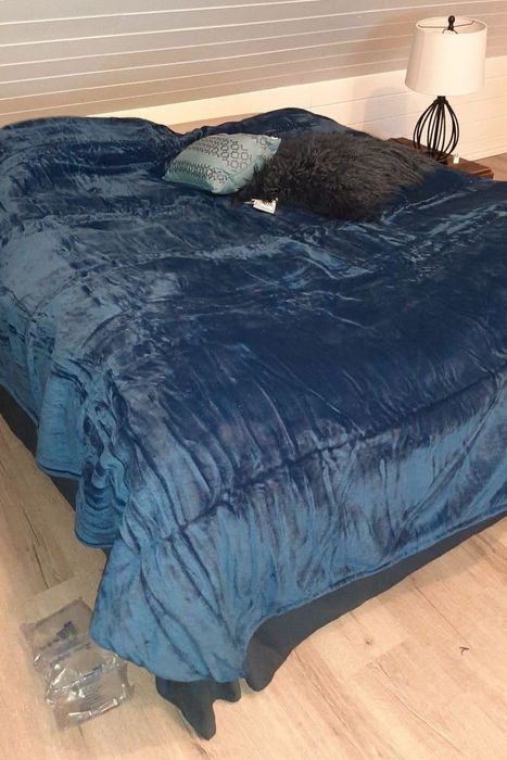 A reviewer posted an image of a blue blanket on a bed.