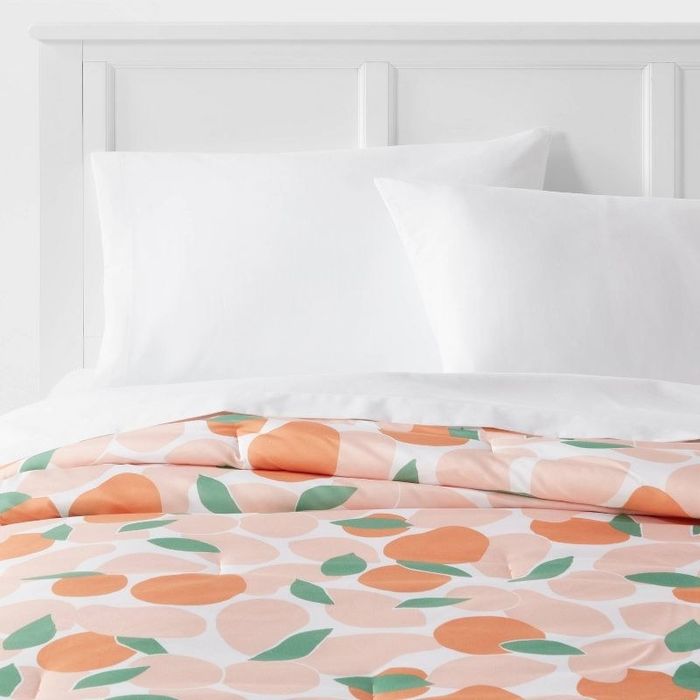 A bed featuring an orange-printed comforter, adding a vibrant and cheerful touch to the room.