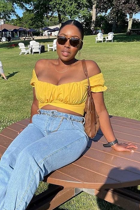 A reviewer sporting the yellow top in a park setting.