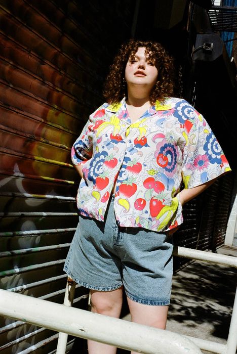 A model wearing a button-down shirt with a vibrant, psychedelic print