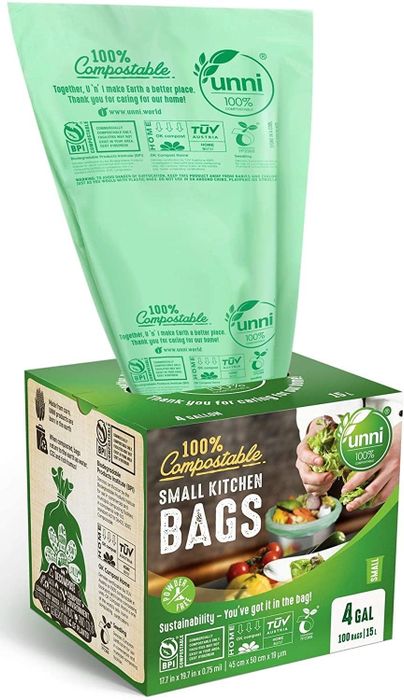 A cardboard box containing trash bags, with one green liner peeking out from the top.