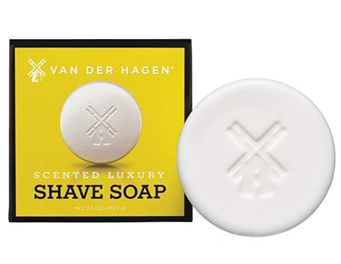 The soap bar box placed next to a round white bar with a windmill design carved into it.