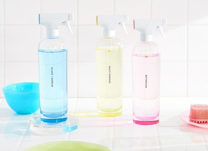 The same three bottles, each filled with differently colored liquids, corresponding to the colored tabs on the lids of the spray bottles.