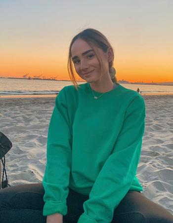 A reviewer wears the green version of the item.