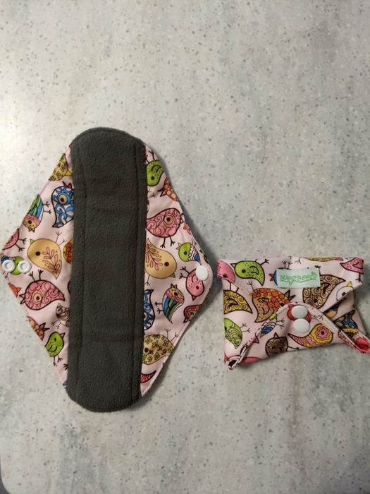 A reviewer's photo showcasing a reusable pad featuring printed wings.