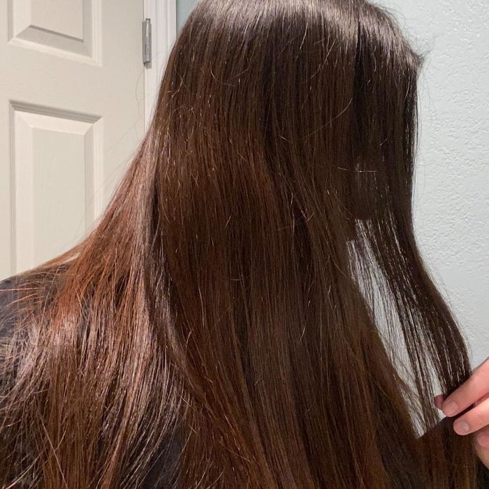 A reviewer proudly displaying their shiny hair after washing with the shampoo bar.