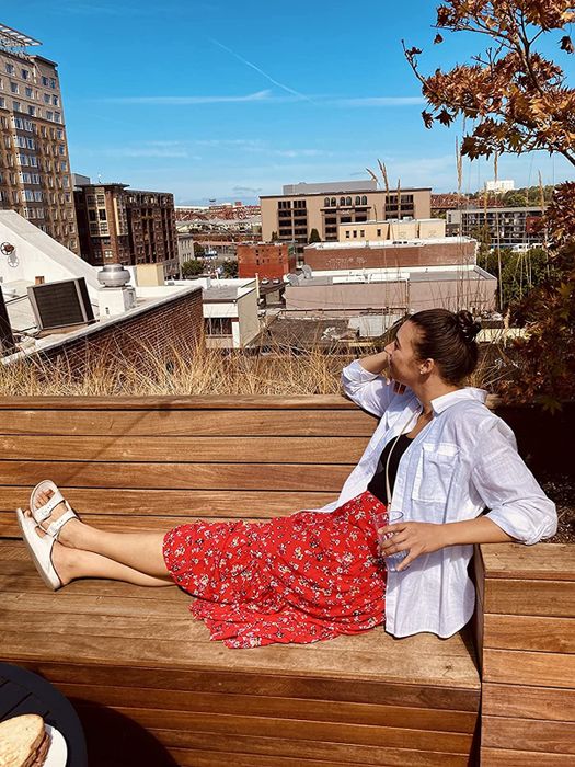 Reviewer wearing a midi floral dress with a white shirt draped over as a cover-up.
