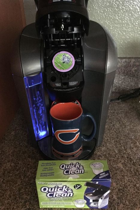 A photo of a reviewer showing the open Keurig with a cleaning cup placed inside