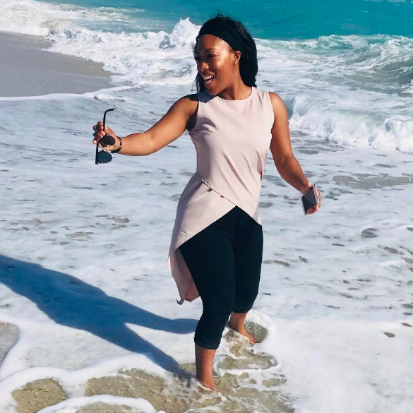 A customer review photo of them wearing the apricot blouse on the beach