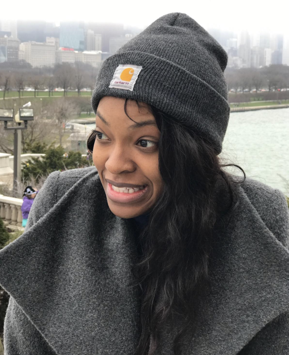 A female reviewer is seen wearing the charcoal-colored beanie.
