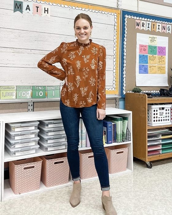 A customer review photo of them wearing denim jeans paired with the burnt orange chiffon blouse