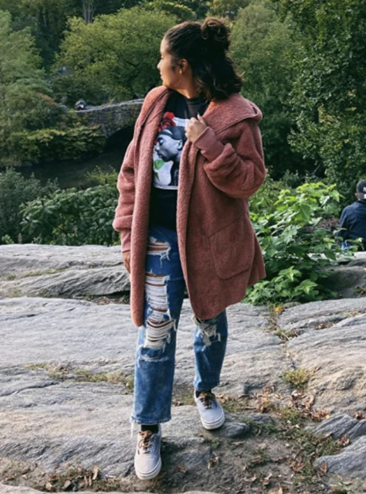 A reviewer showcasing the pink coat.