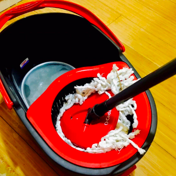 The reviewer squeezing excess water from a hole in the bucket