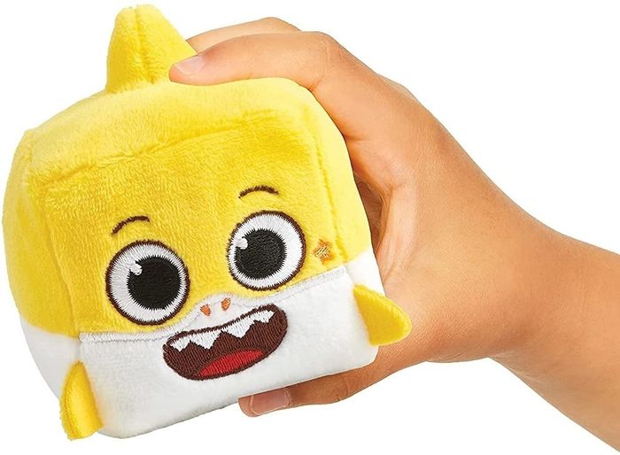 A yellow, cube-shaped plush toy featuring the Baby Shark character.