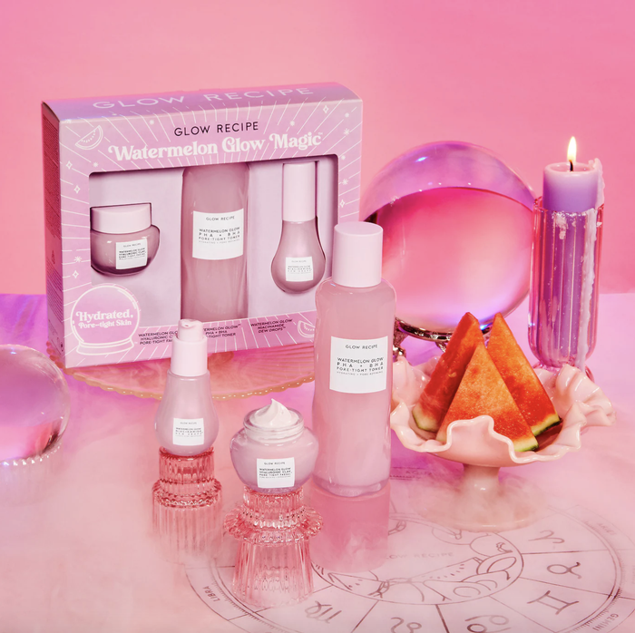 The packaged Watermelon Glow Magic Glow Recipe bottles, accompanied by the three product containers and a crystal ball placed next to them.
