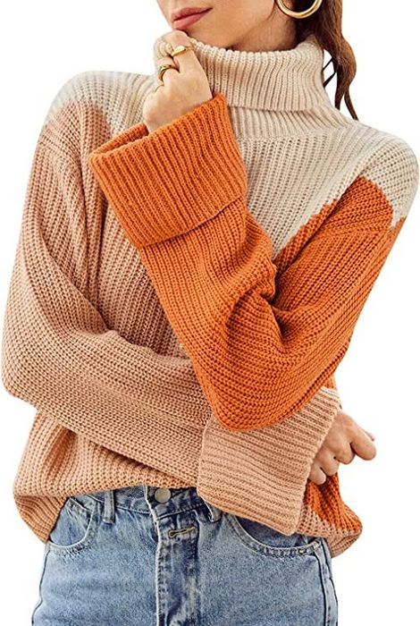 A model wearing the turtleneck sweater in a mix of cream, blush, and orange tones