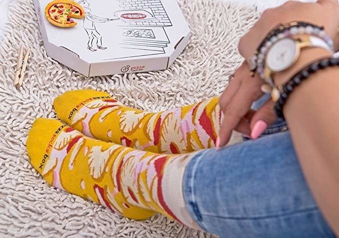 model showcasing yellow Hawaiian pizza-themed socks