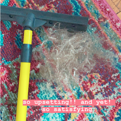 A Mytour Shopping reviewer’s carpet, showing a hairball next to the broom, illustrating the mess that needs cleaning.