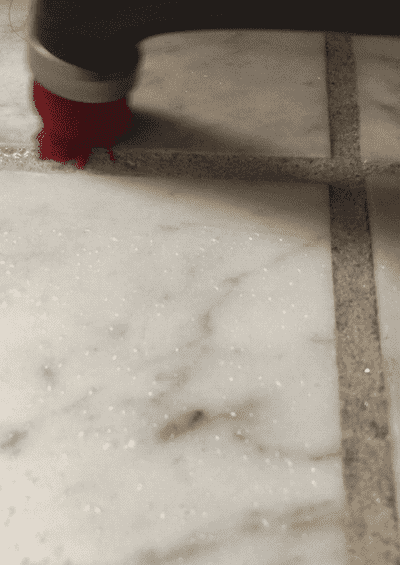 A GIF of Natalie demonstrating the power scrubber on her tile floors
