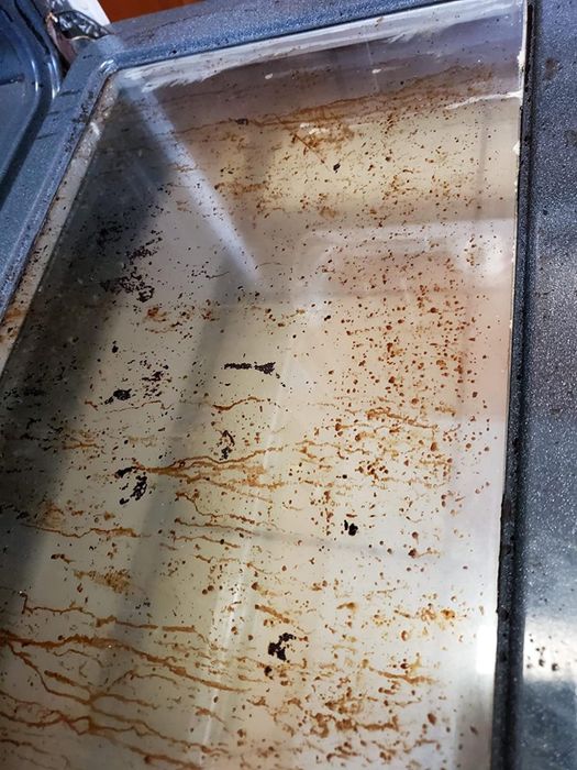 A glass oven door covered in brown, drippy stains.