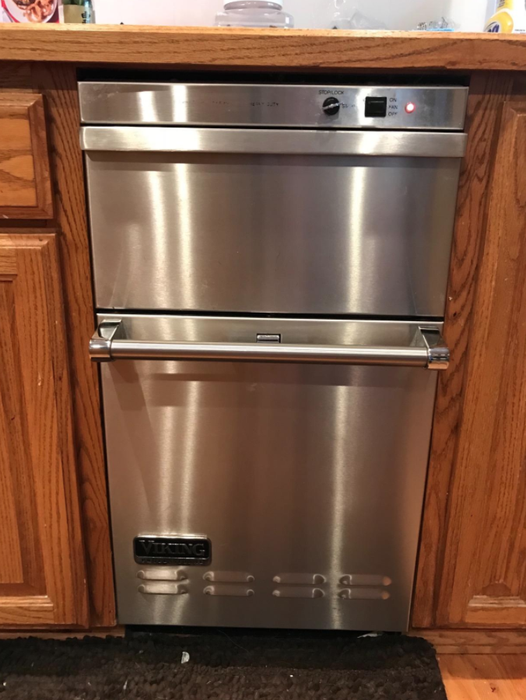 The same dishwasher now gleaming after using the cleaning spray