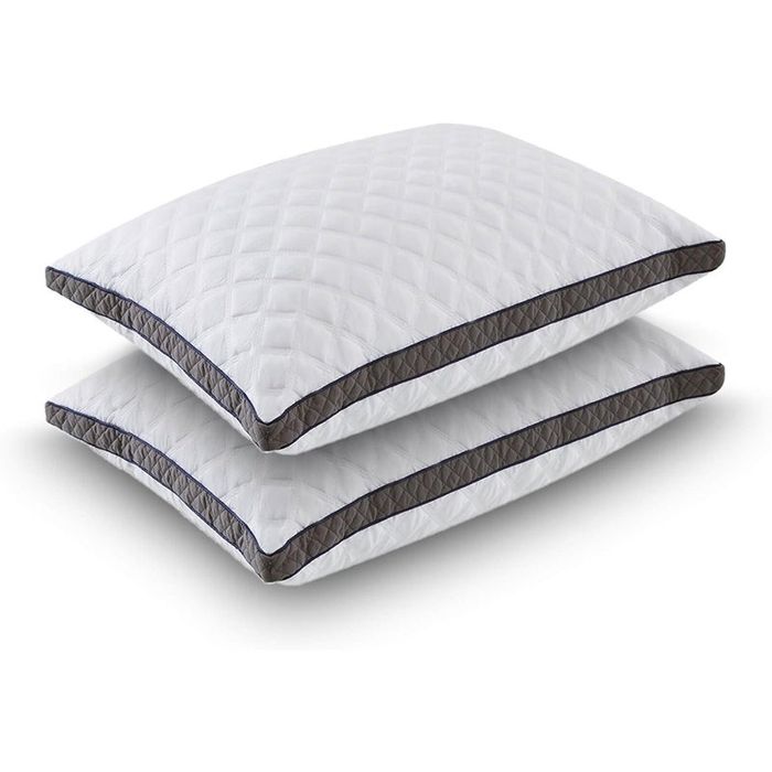 Two white quilted pillows neatly stacked one on top of the other