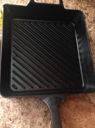 The same cast-iron pan now completely free of burnt-on food, looking clean and restored.