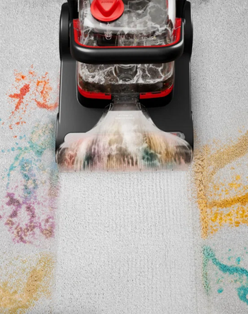 A vacuum cleaner moves over a dirty carpet with colorful stains, visibly cleaning them up and leaving a fresh, clean trail behind.