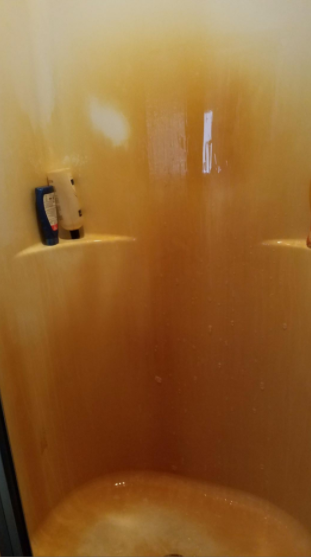 A reviewer’s photo showing a shower filled with rust stains, creating an unpleasant sight.