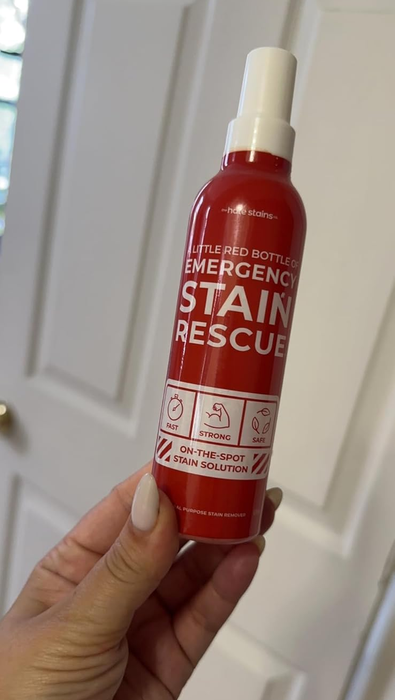 A reviewer is holding a bottle of the product.