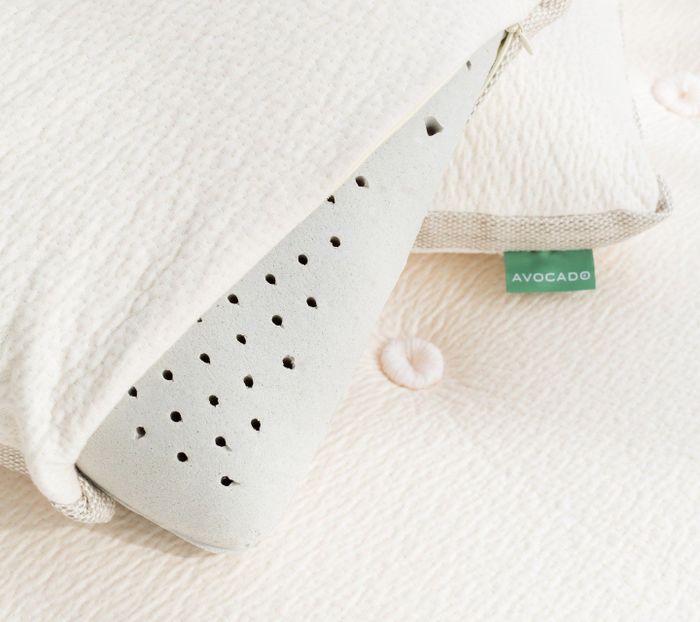 A close-up view of the pillow with its cover pulled back, revealing the charcoal-infused latex material