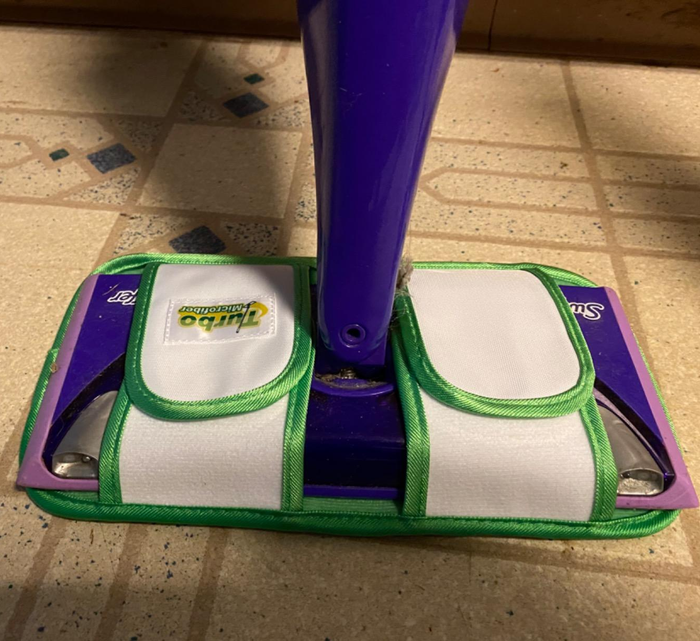 The microfiber mop pad attached to a reviewer's Swiffer, ready to clean.