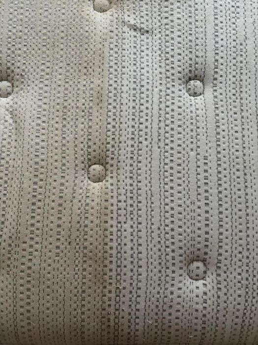 A reviewer's mattress with the right side cleaned and the left side still showing stains.
