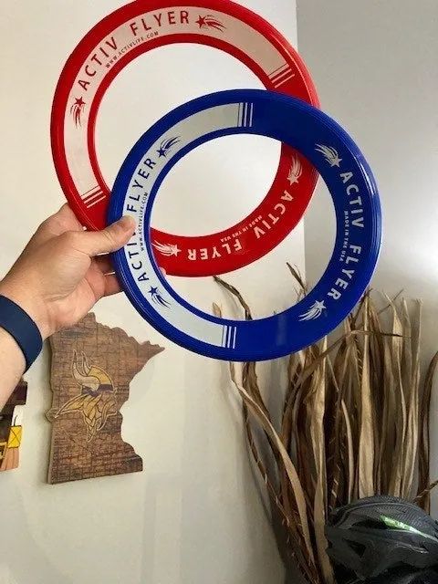 A reviewer's photo showing them holding a pair of red and blue flying rings.