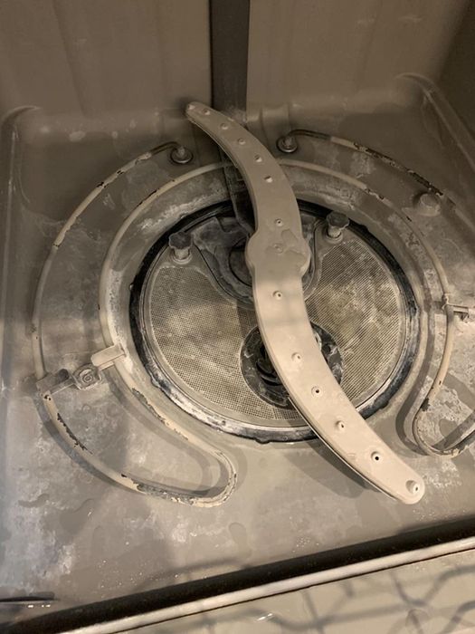 before image showing a dishwasher covered in hard water stains and limescale buildup