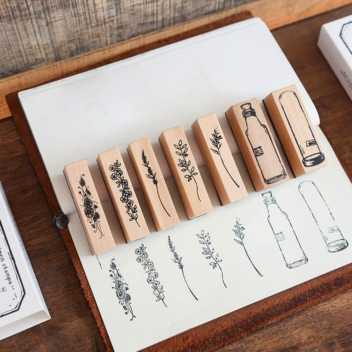 A set of delicate wooden stamps featuring floral stems and long bottles
