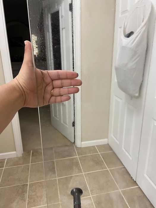 same reviewer's hand behind the door, now sparkling clean after using the cleaner