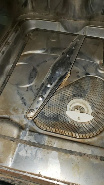 A reviewer's photo showing the inside of a dirty dishwasher before cleaning.