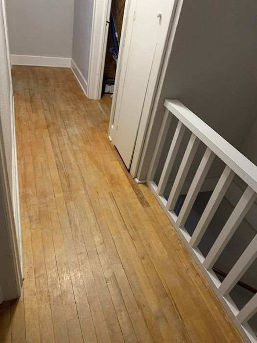On the left: an old hardwood floor marked with scratches, scuffs, and fading patches.