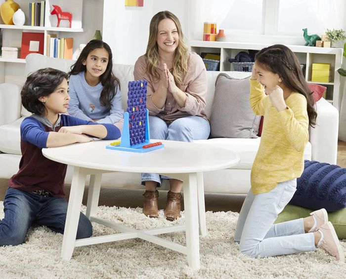 A family enjoying a lively game of Connect 4 Spin together.