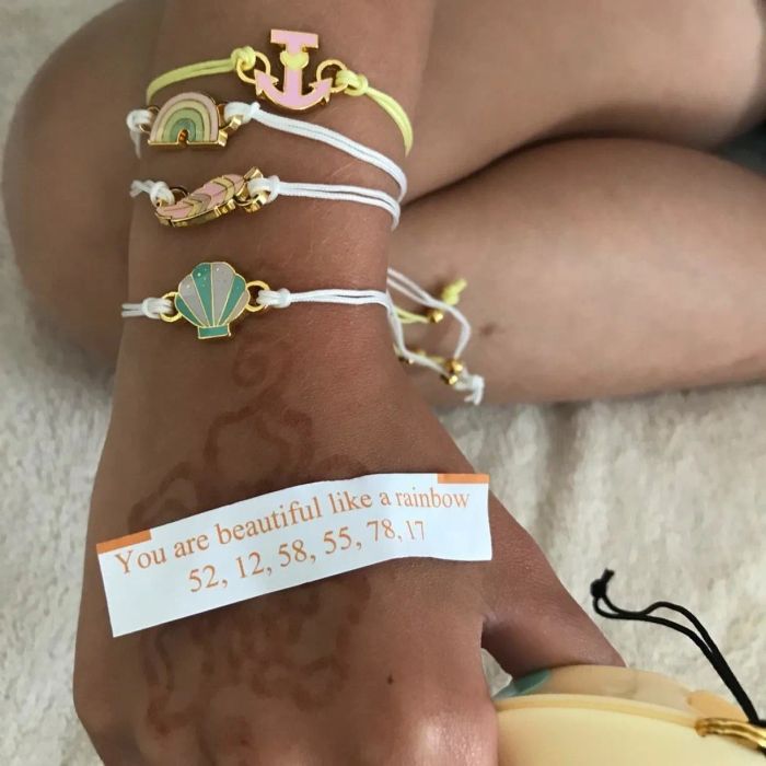 The reviewer is showcasing their hand adorned with four charm bracelets, proudly presenting this paper fortune.